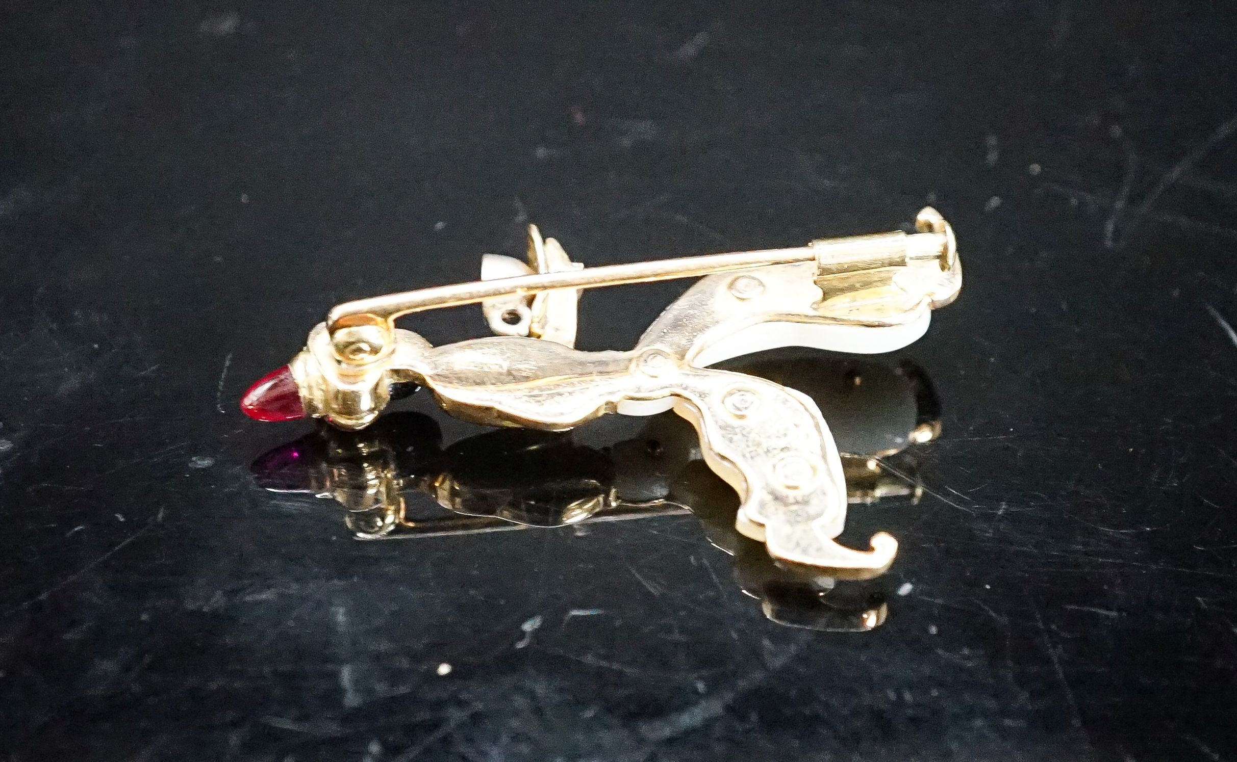 A 20th century Viennese 585 yellow metal, black enamel, mother of pearl and cabochon set brooch, modelled as a Blackamoor, 41mm, gross weight 7.2 grams.